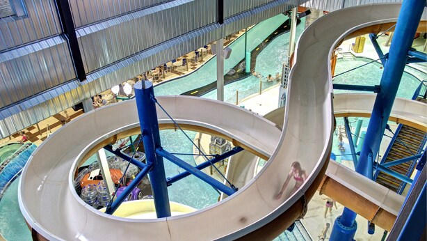A large indoor water slide with multiple lanes and a central support structure. - Metropolis Resort (Eau Claire)