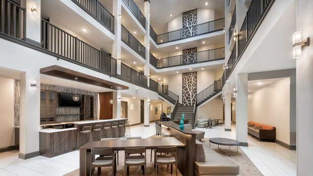 A spacious multi-level interior with a central dining area, kitchen, and seating areas. - SPRINGHILL SUITES BY MARRIOTT CONYERS (Conyers)