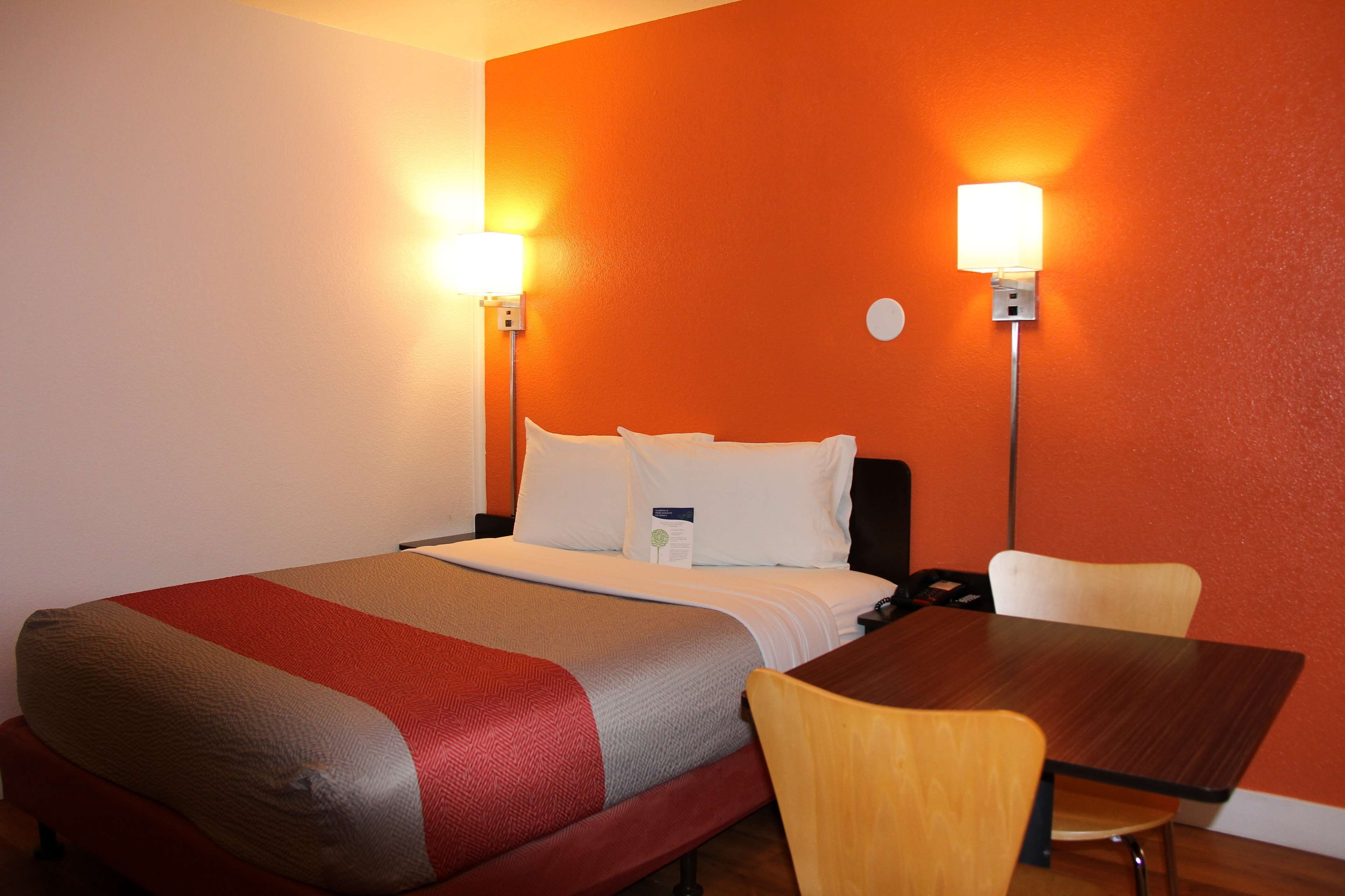 Ein Hotelzimmer mit Bett, Nachttischen und einem Sessel.