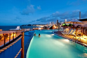 Un espace piscine offrant une vue sur les gratte-ciel d'une ville au crépuscule.