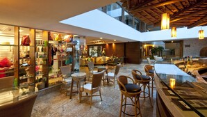 A modern interior with a glass storefront, seating area, and a bar.