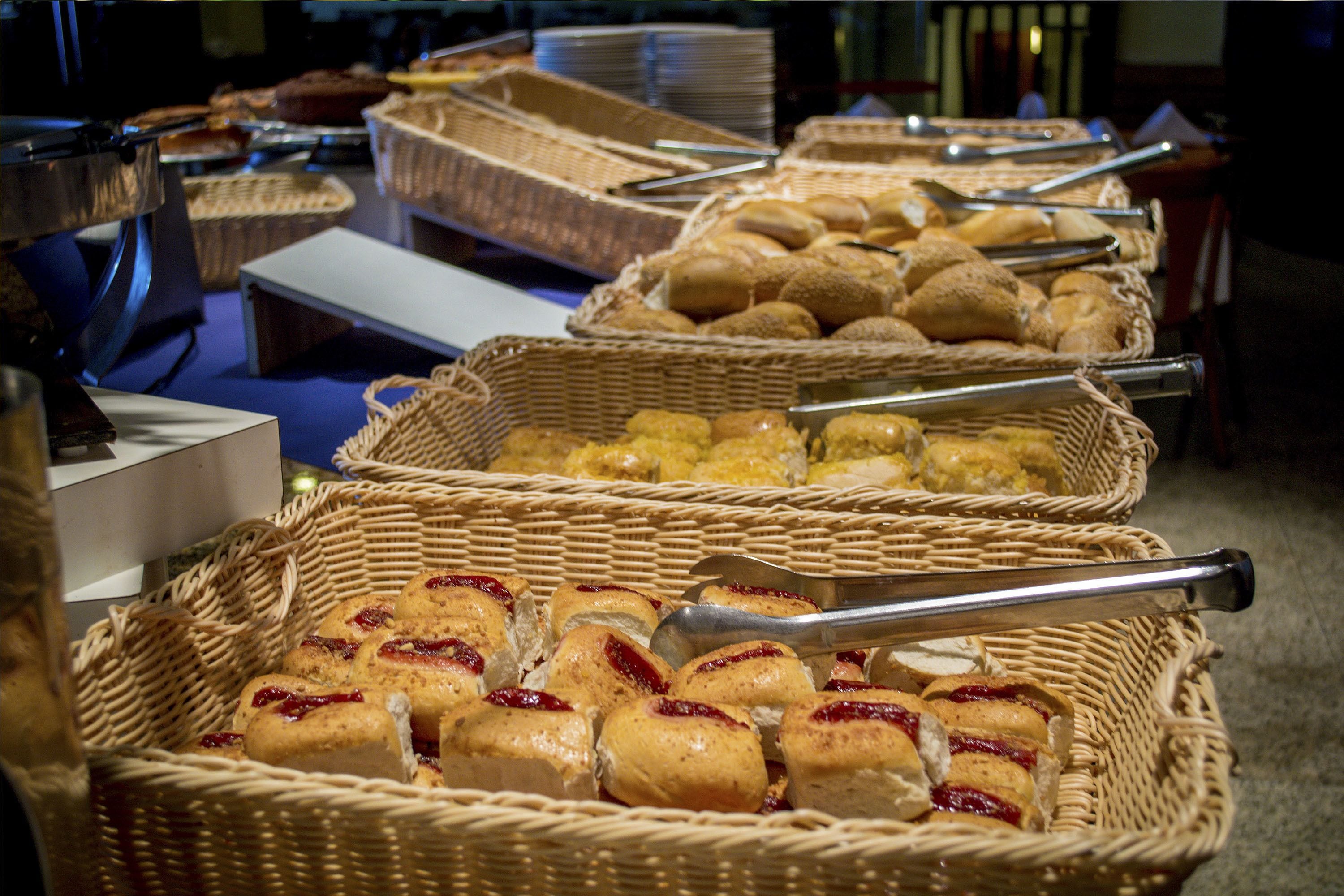A buffet with various food items in wicker baskets.