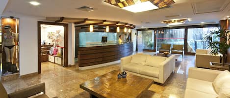 Hall dell'hotel con reception, area relax e vista sull'esterno.