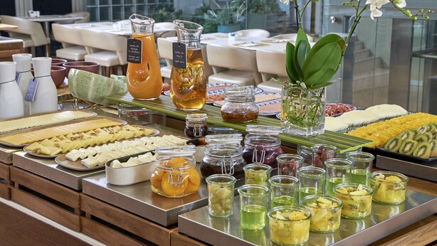 A buffet with various food items, including fruits, cheeses, and condiments. - NH Coimbra Dona Inês (Coimbra)