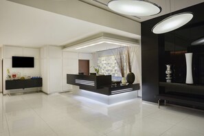 Welcome to our reception area, featuring a sleek reception desk, flat-screen TV, and stylish cabinetry.