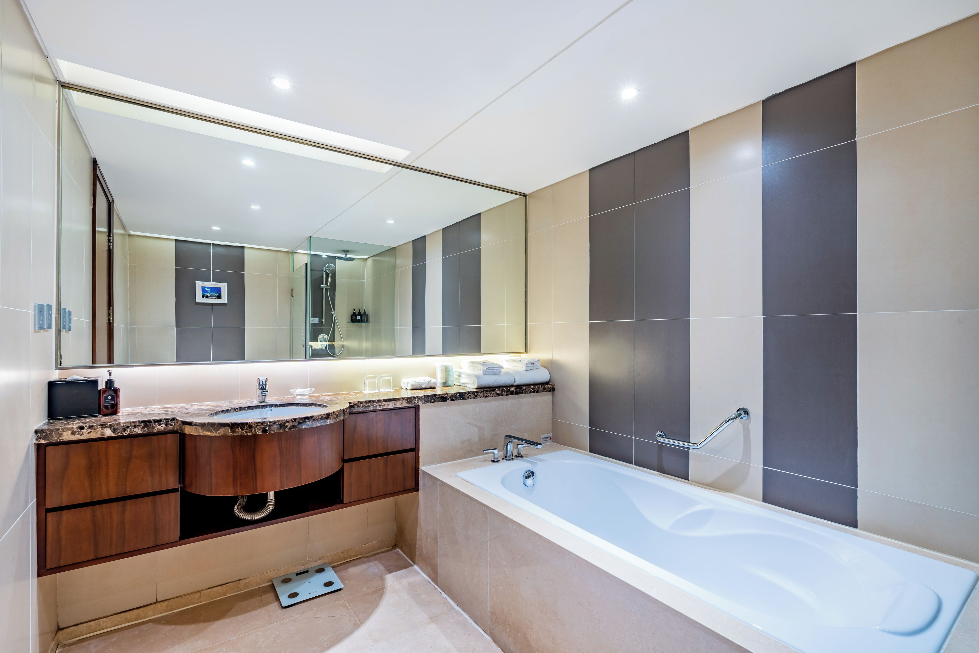 A modern bathroom with two sinks, a large bathtub, and a mirror above the vanity.