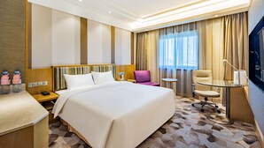 A hotel room with a large bed, a desk with a chair, a small table, and a TV. - Grand Skylight Catic Hotel Beijing (Beijing)
