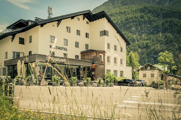 Un hôtel avec une enseigne indiquant « POHOTEL » et un café appelé « RESTAURANT » situé devant.