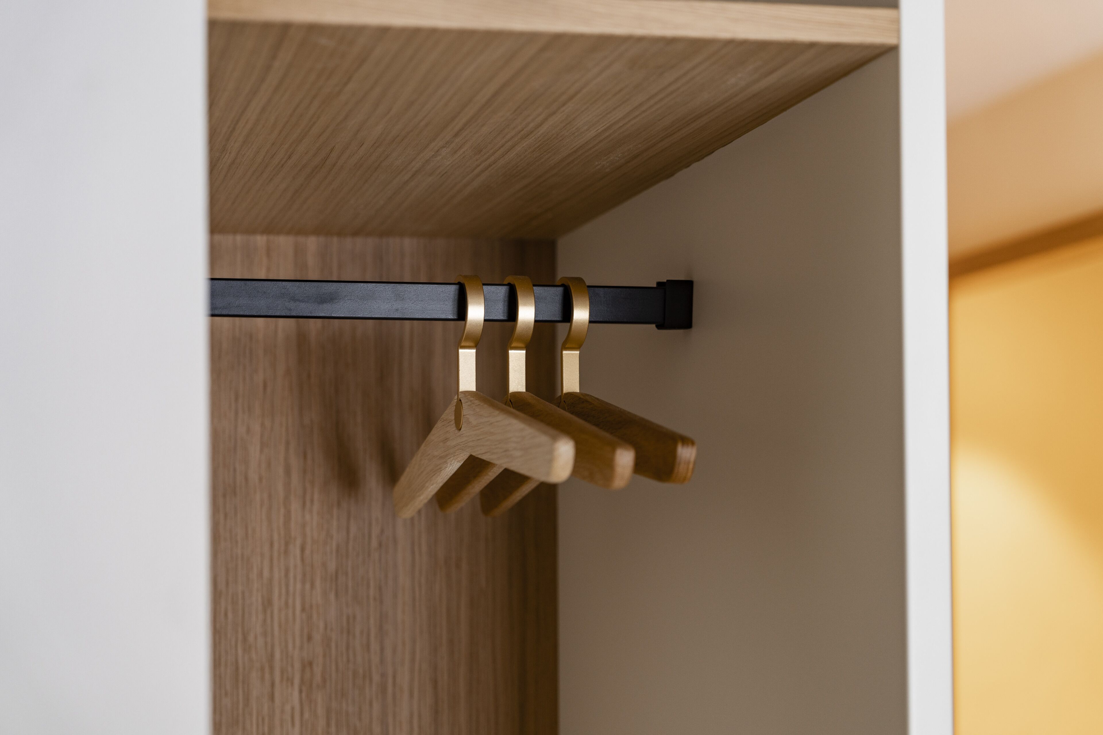 A wooden door with a black metal handle and a wooden doorstop.