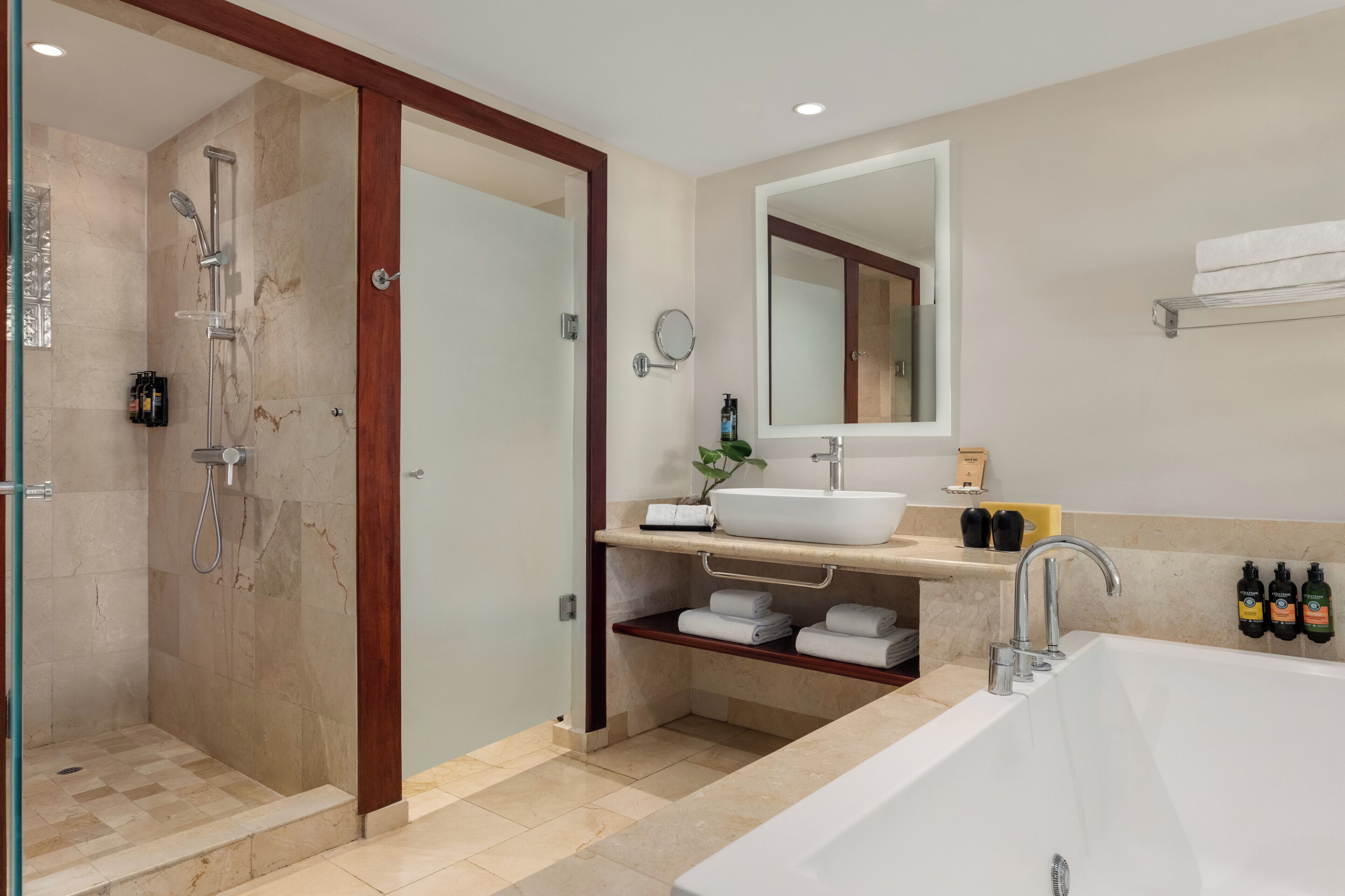 Een moderne badkamer met een inloopdouche, een ruim bad, een wastafel en een spiegel.