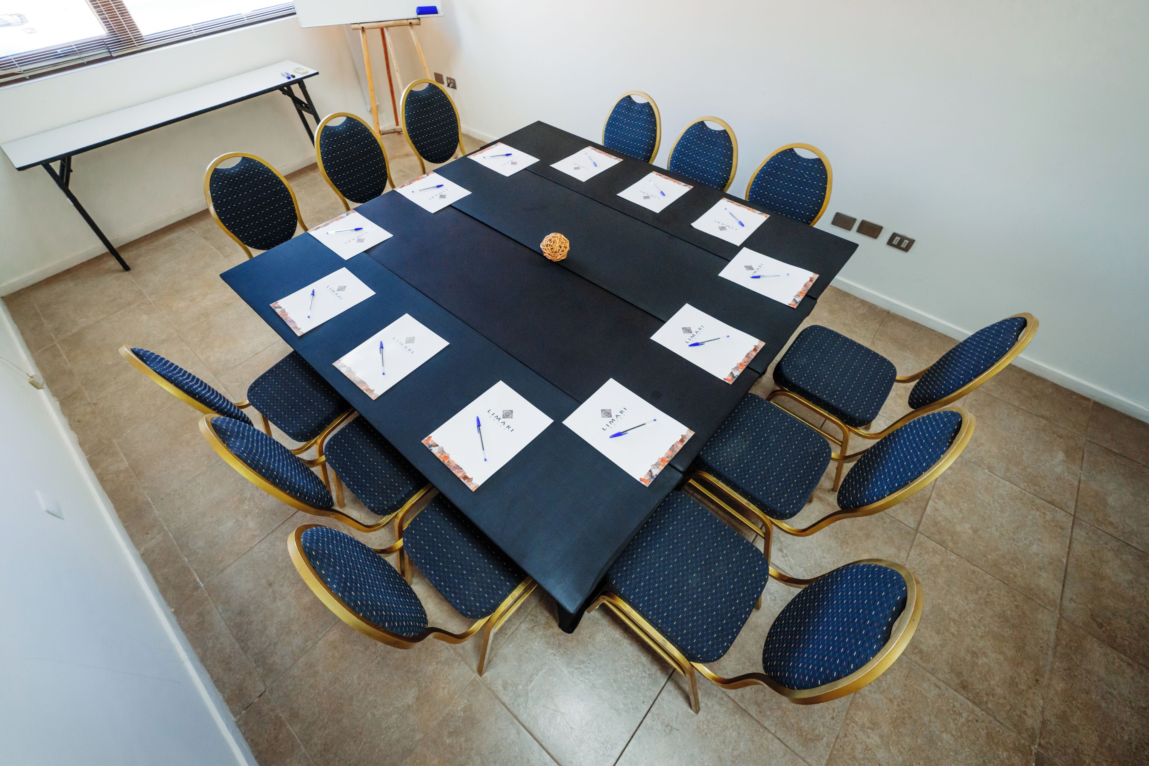 Ein Konferenzraum mit einem großen Tisch, Stühlen und einer Whiteboard-Tafel.