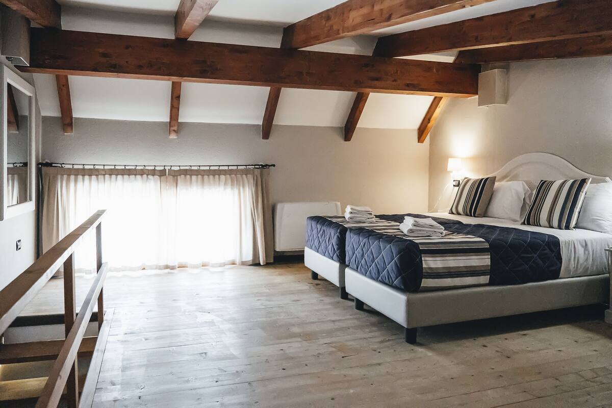 Une chambre à coucher avec un lit, une table de chevet et un banc en bois.