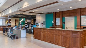 A hotel lobby with a reception desk, a coffee station, and a seating area. - Hilton Garden Inn Naperville/Warrenville (Warrenville)