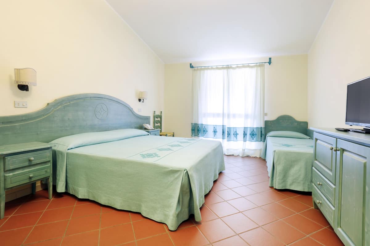 A hotel room with two beds, a TV, a dresser, and a nightstand.