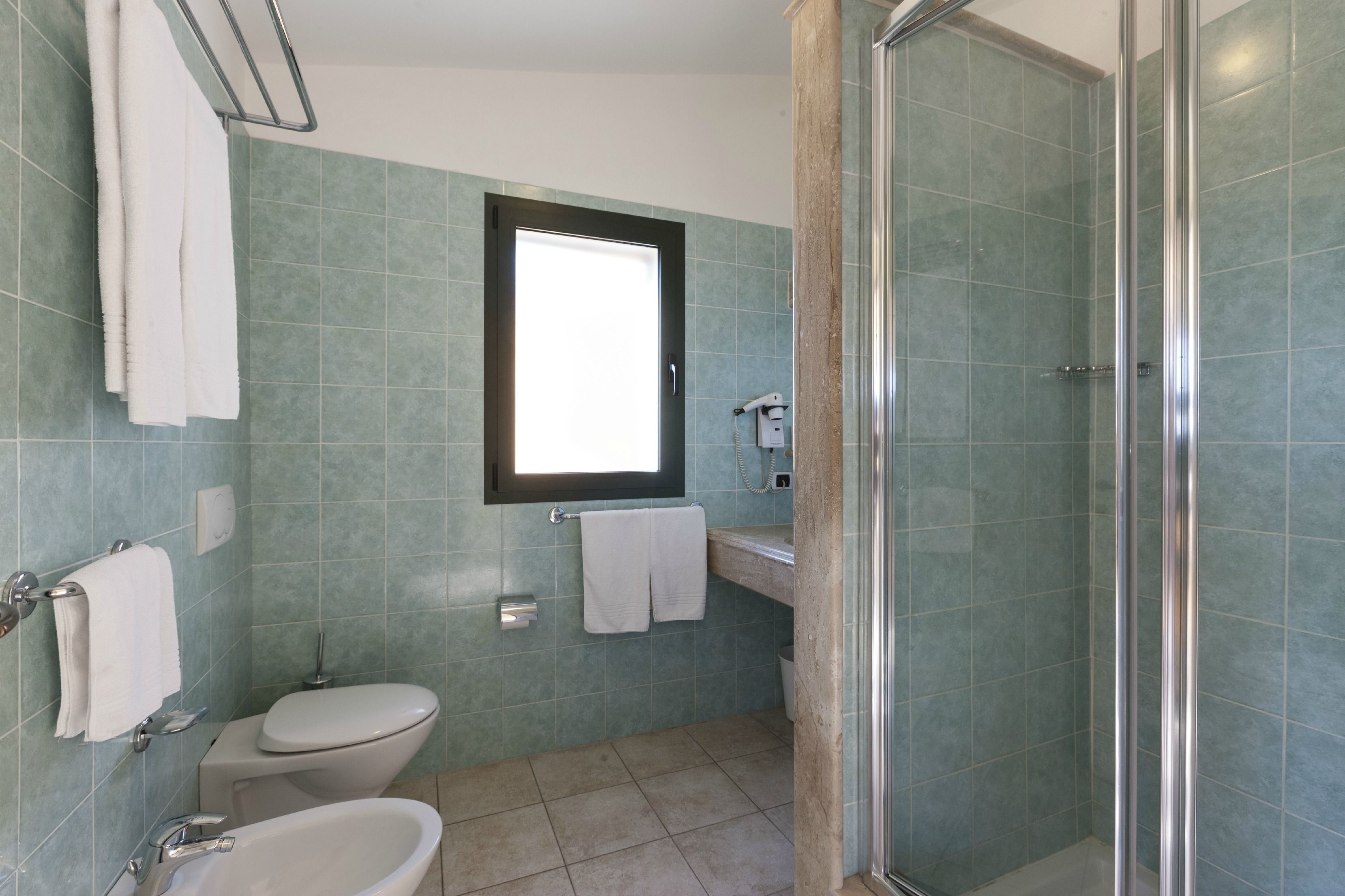 Un baño con inodoro, lavabo y ducha.