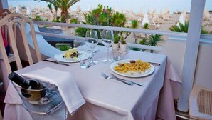 Mesa para dos con vistas a la playa y palmeras.