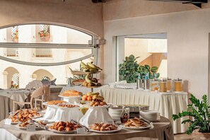 Una mesa de buffet con distintos alimentos y una planta.