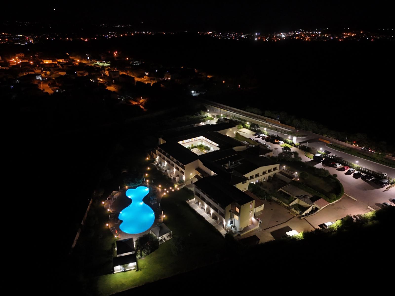 Ein Hotel mit Schwimmbad, Parkplatz und mehreren Gebäuden.