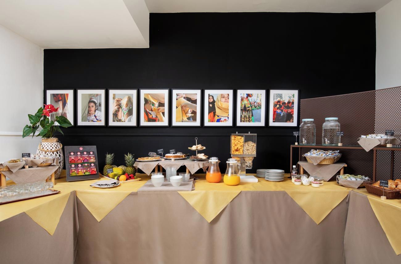 Ein reichhaltiges Frühstücksbuffet mit verschiedenen Speisen und einer Wand mit gerahmten Fotos.