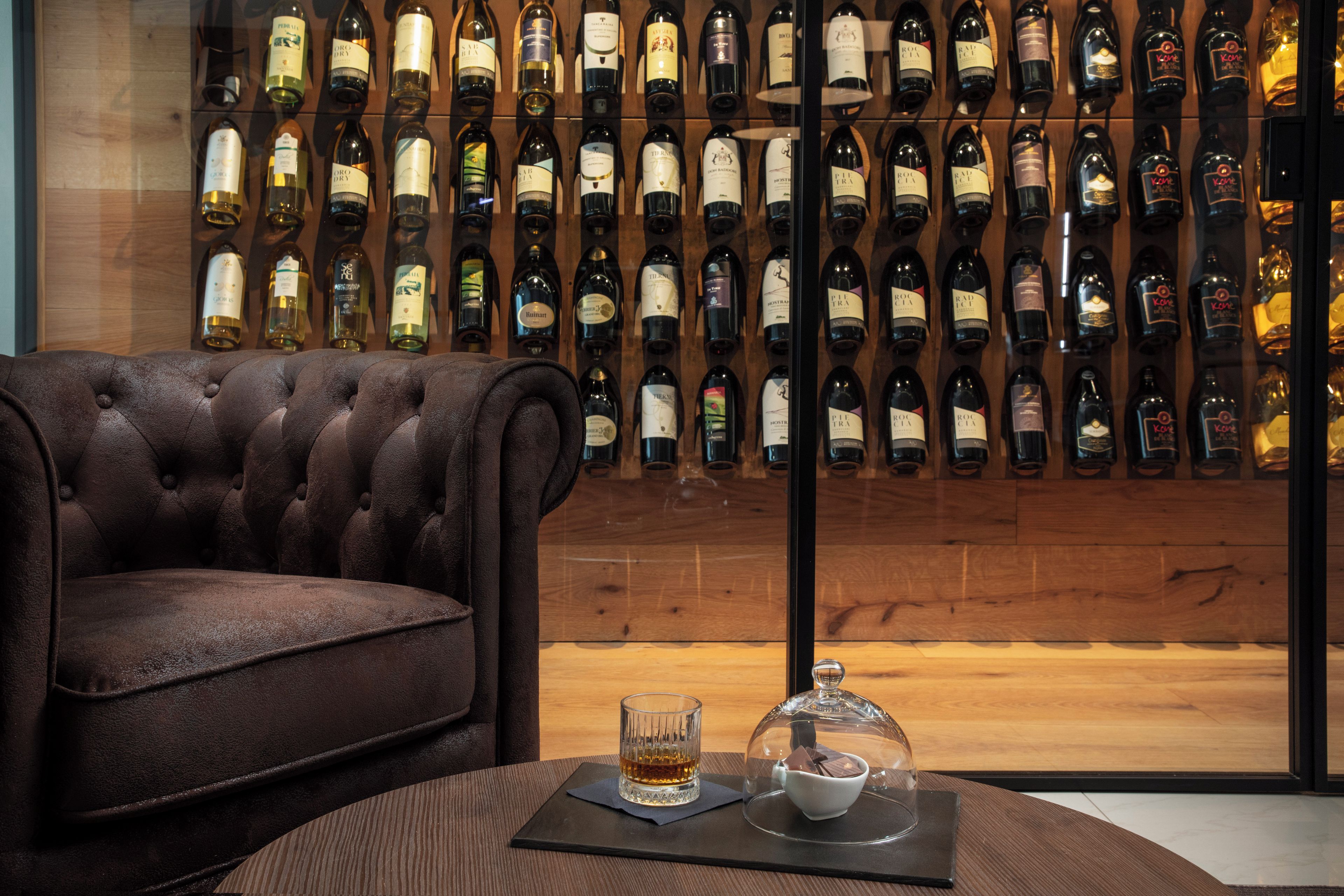 Un coin bar avec un canapé en cuir et un meuble à bouteilles bien garni.