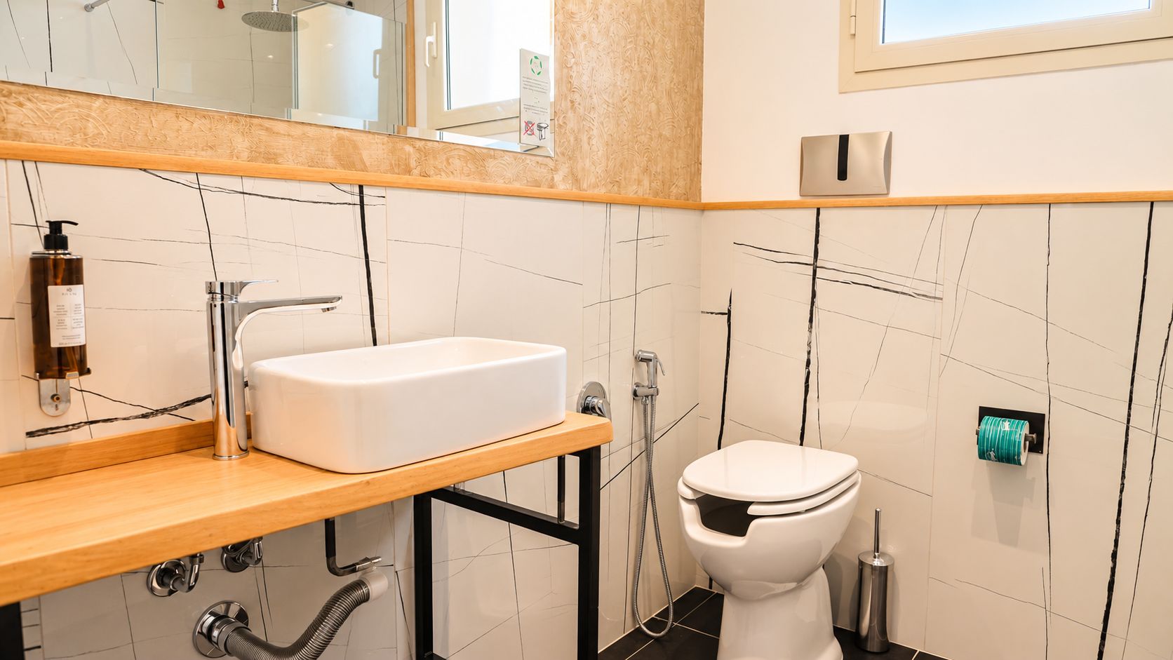 Un baño moderno con un lavabo blanco, un inodoro y una ducha.