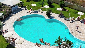 Una piscina al aire libre de temporada, sombrillas