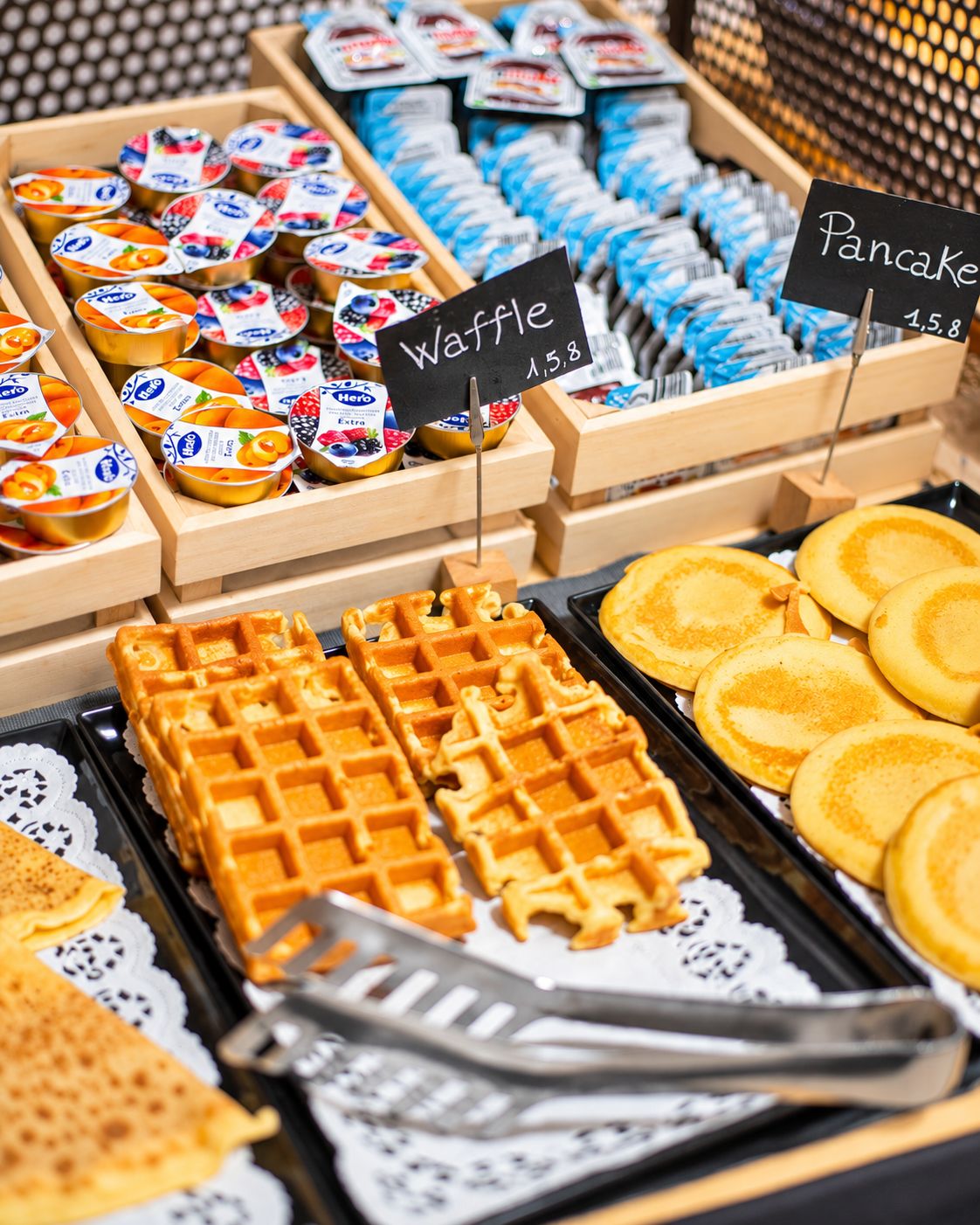 A selection of waffles, pancakes, and yogurt parfaits on display.