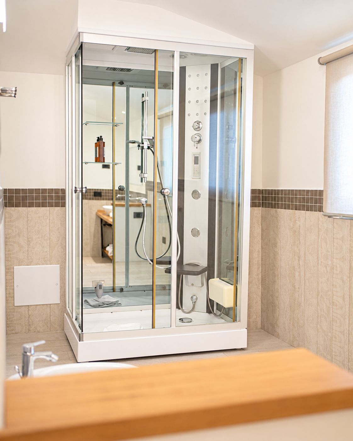 A modern bathroom with a glass-enclosed shower, a visible toilet, and a sink.