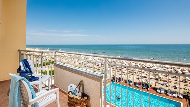 Un balcone con vista sulla spiaggia e su una piscina.