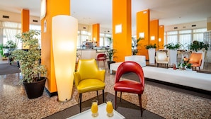 Una hall con pareti arancioni, una reception e zone relax.