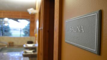 Un panneau indiquant « SAUNA » est affiché sur un mur, signalant la présence d’un espace sauna.