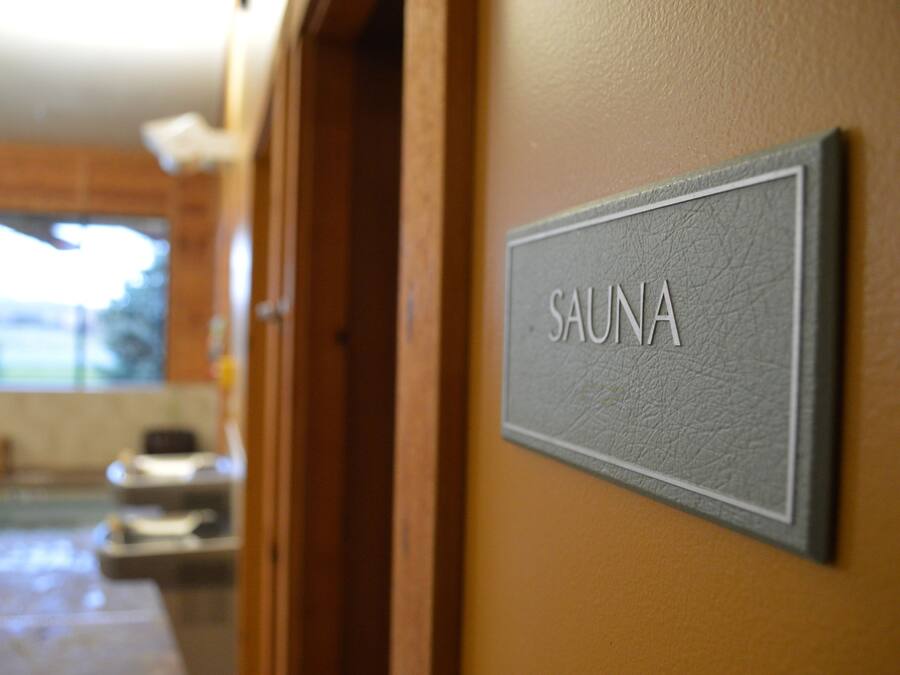 Un panneau indiquant « SAUNA » est affiché sur un mur, signalant la présence d’un espace sauna.