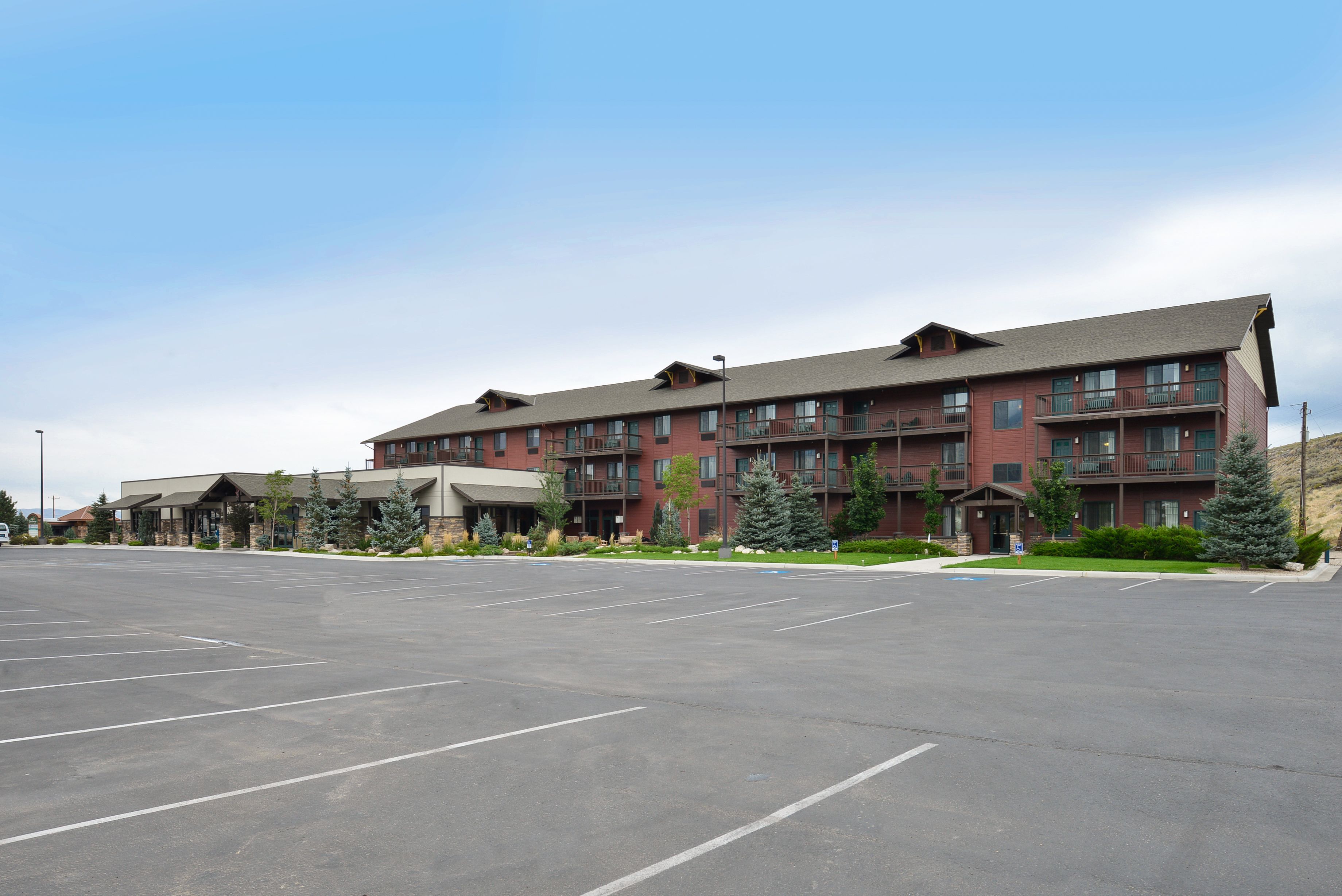 A multi-story hotel with a parking lot in front.