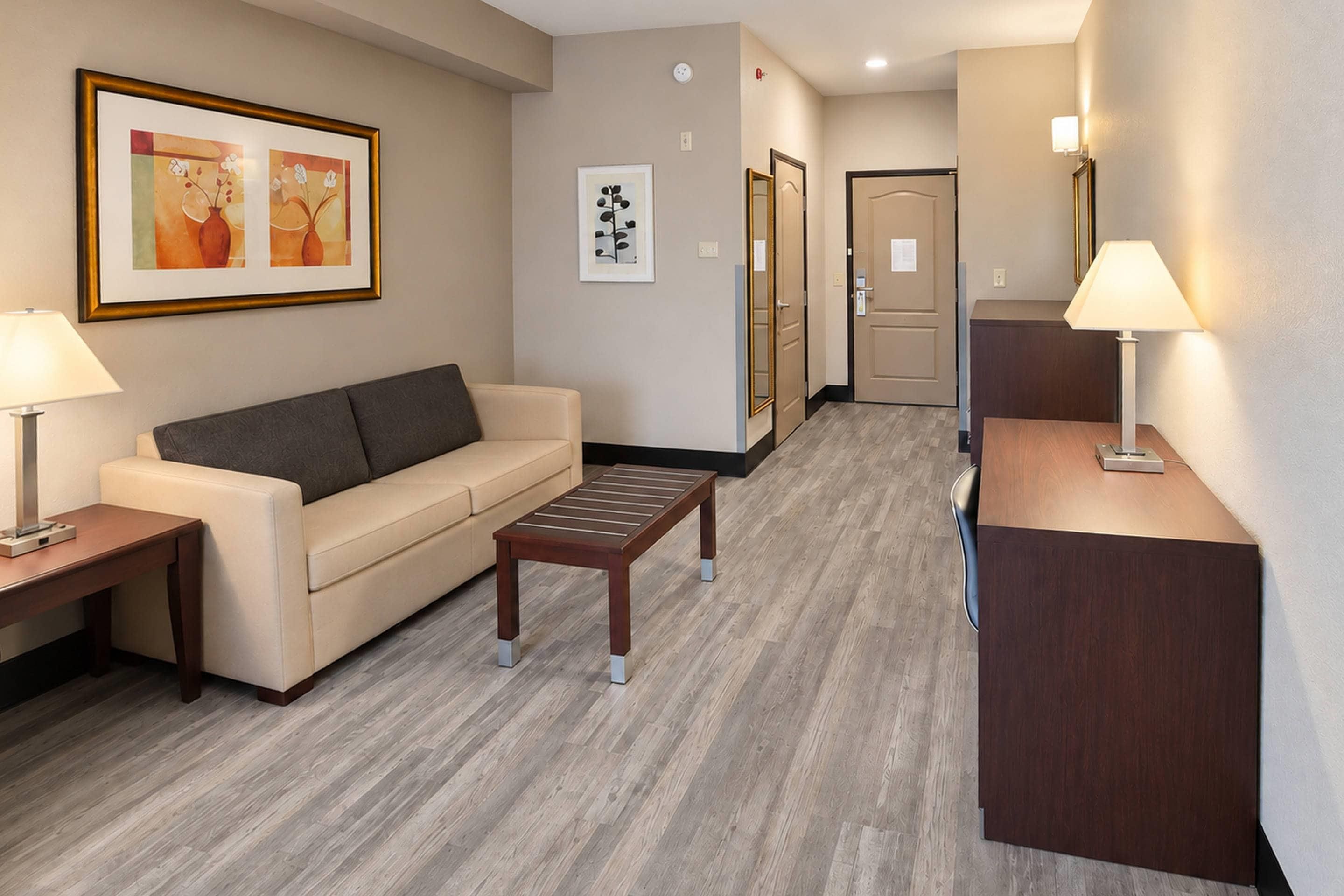 A hotel lobby with a sofa, a coffee table, a desk, and a reception area.