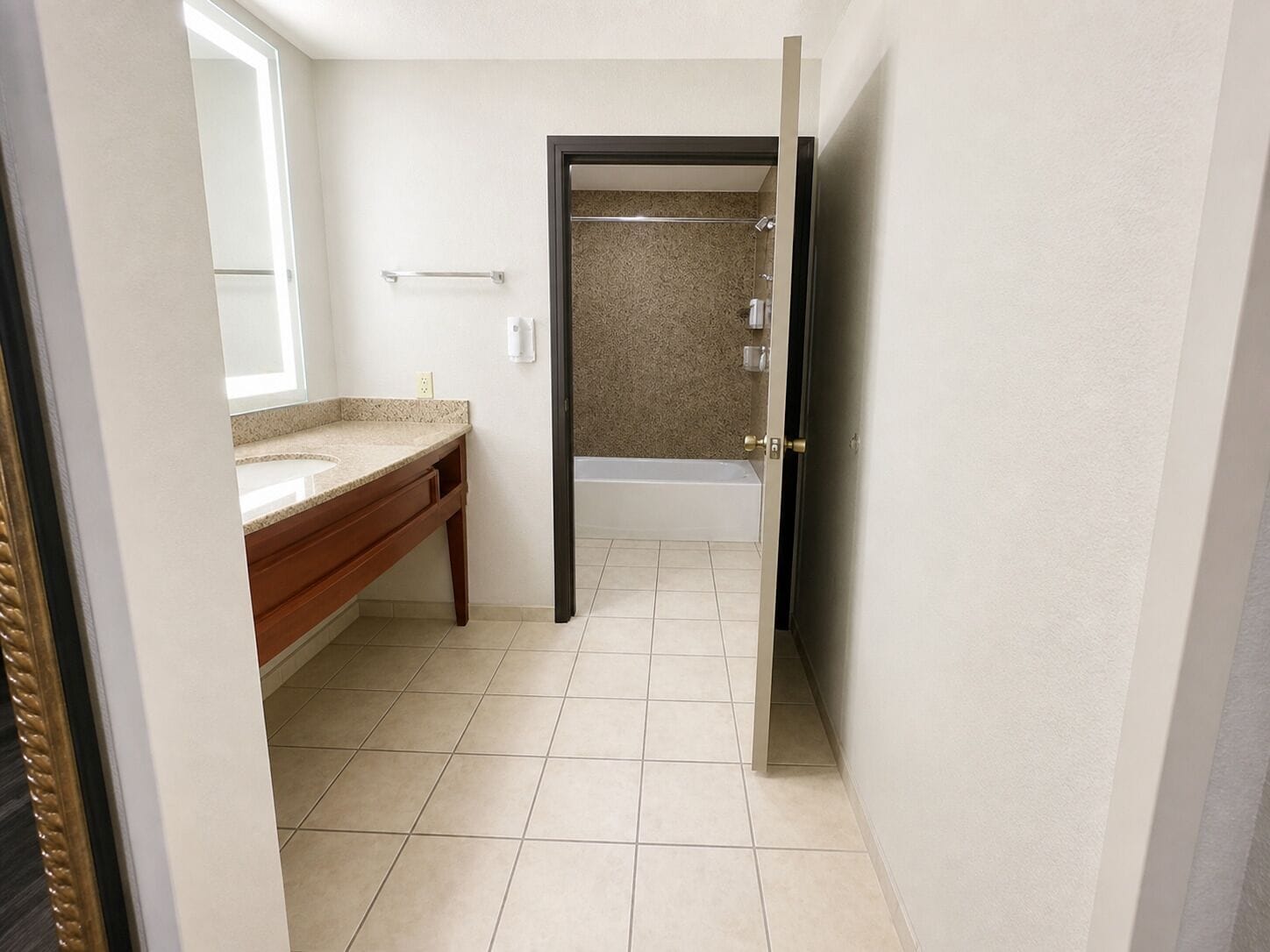 A bathroom with a vanity, a bathtub, and a shower area.