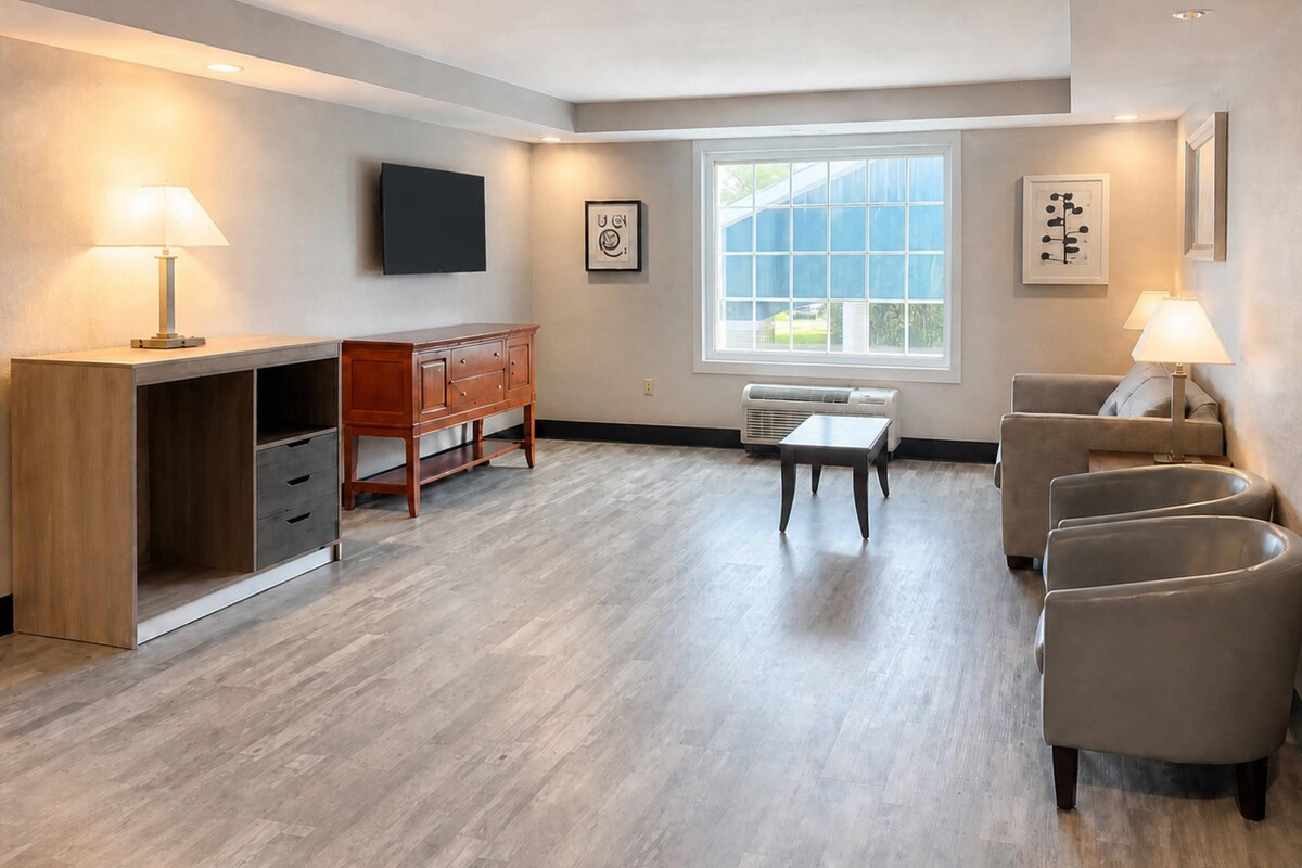 Een moderne woonkamer met een houten bureau, een eettafel en een bank.