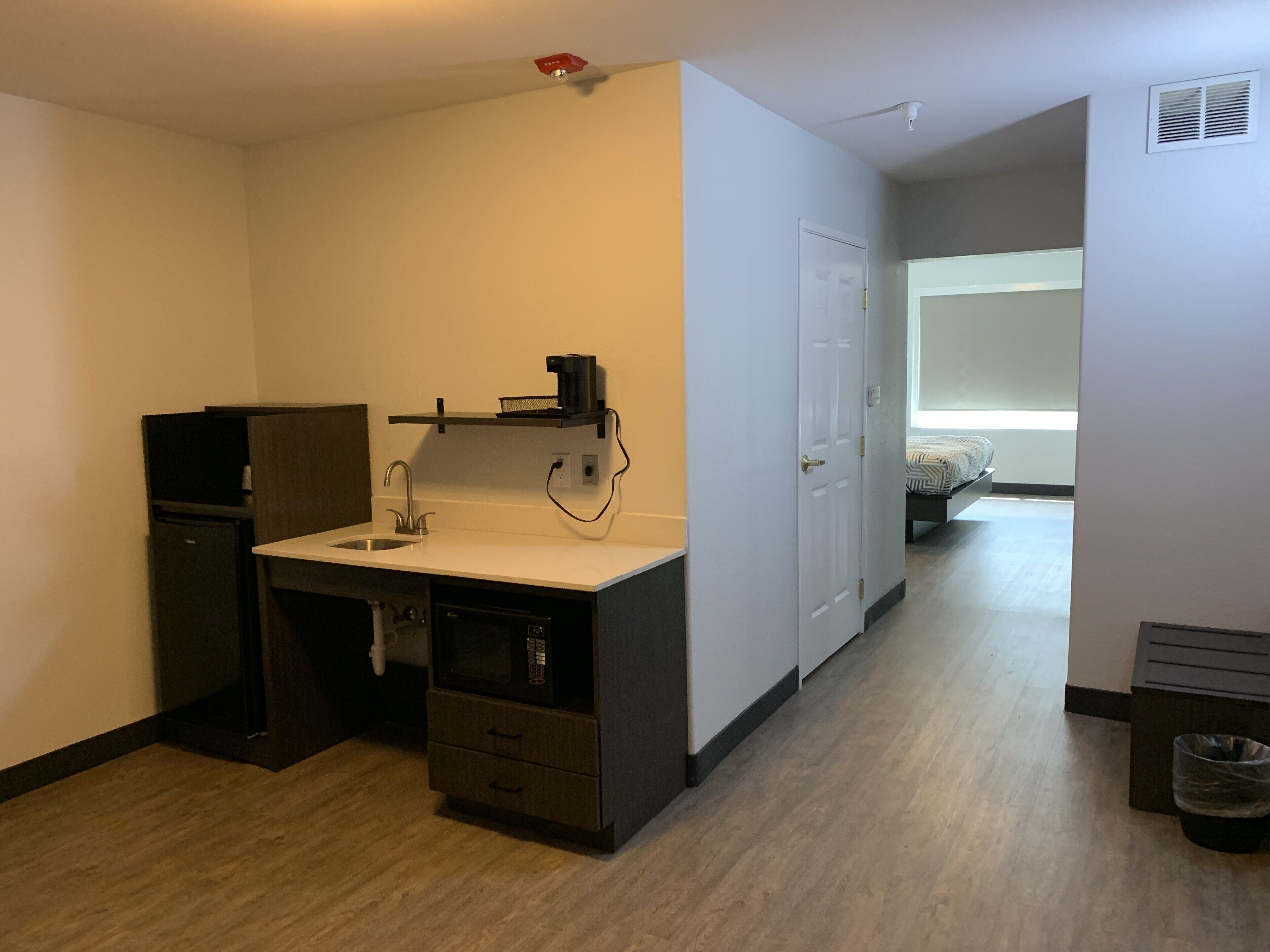 Una cuineta compacta amb un rentaplat, microones i armaris d'emmagatzematge.