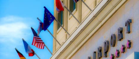 A building with the sign "AIRPORT HOTEL" and multiple flags including the American, European Union, and others.