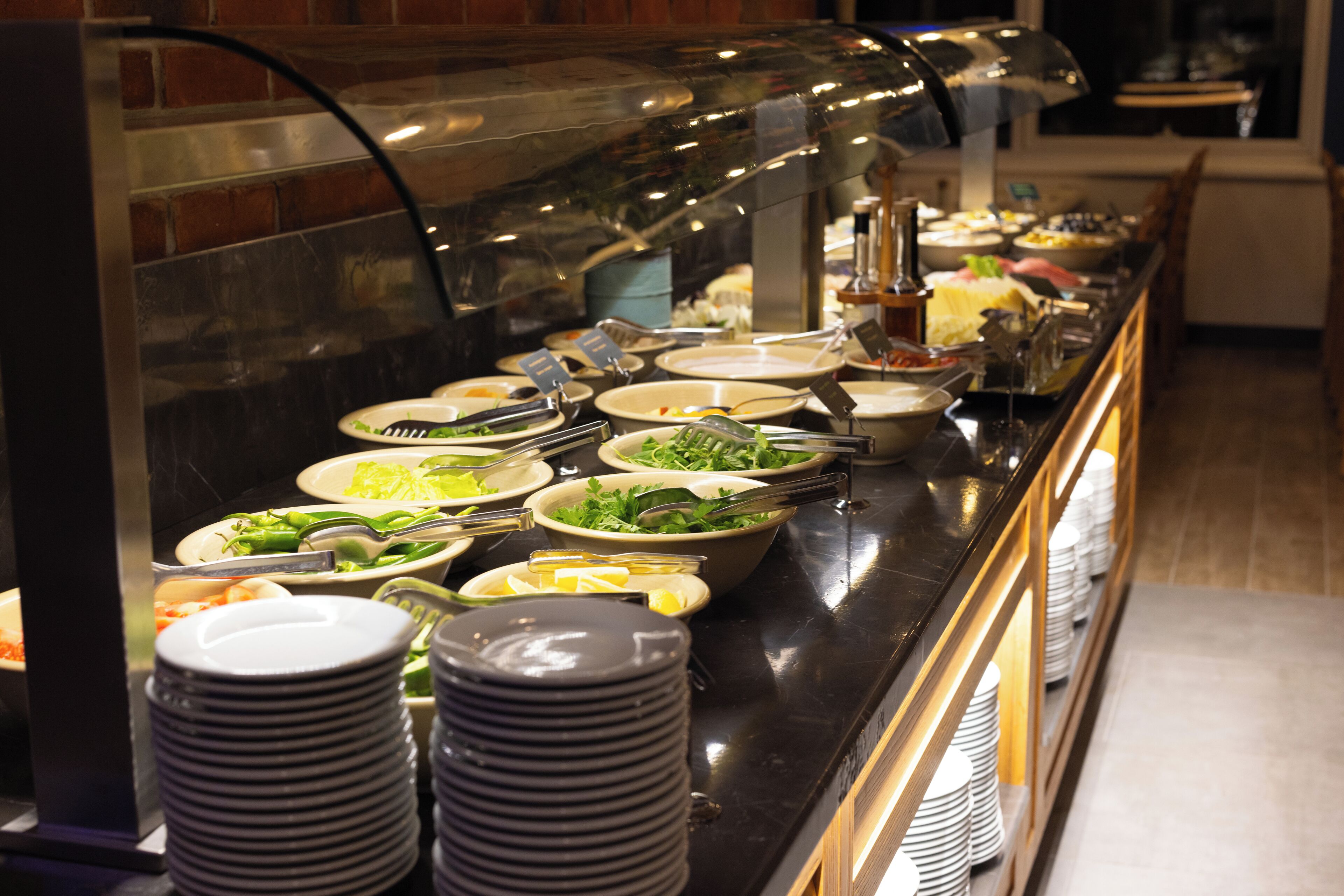 A buffet with various dishes and utensils.