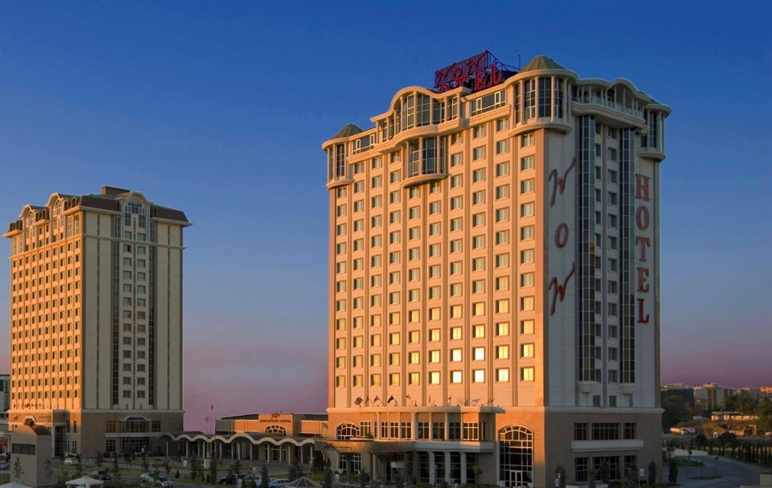 A hotel with a classic architectural design, featuring a prominent 'HOTEL' sign on the facade and multiple balconies.
