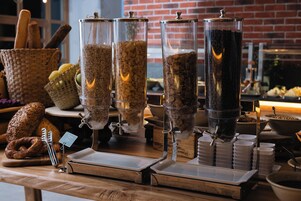 Una mesa de buffet con diferentes dispensadores de alimentos y bandejas de servicio.