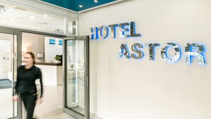 A hotel entrance with a glass door and a wall sign reading "HOTEL ASTOR". - Hotel Astor Kiel by Campanile (Kiel)