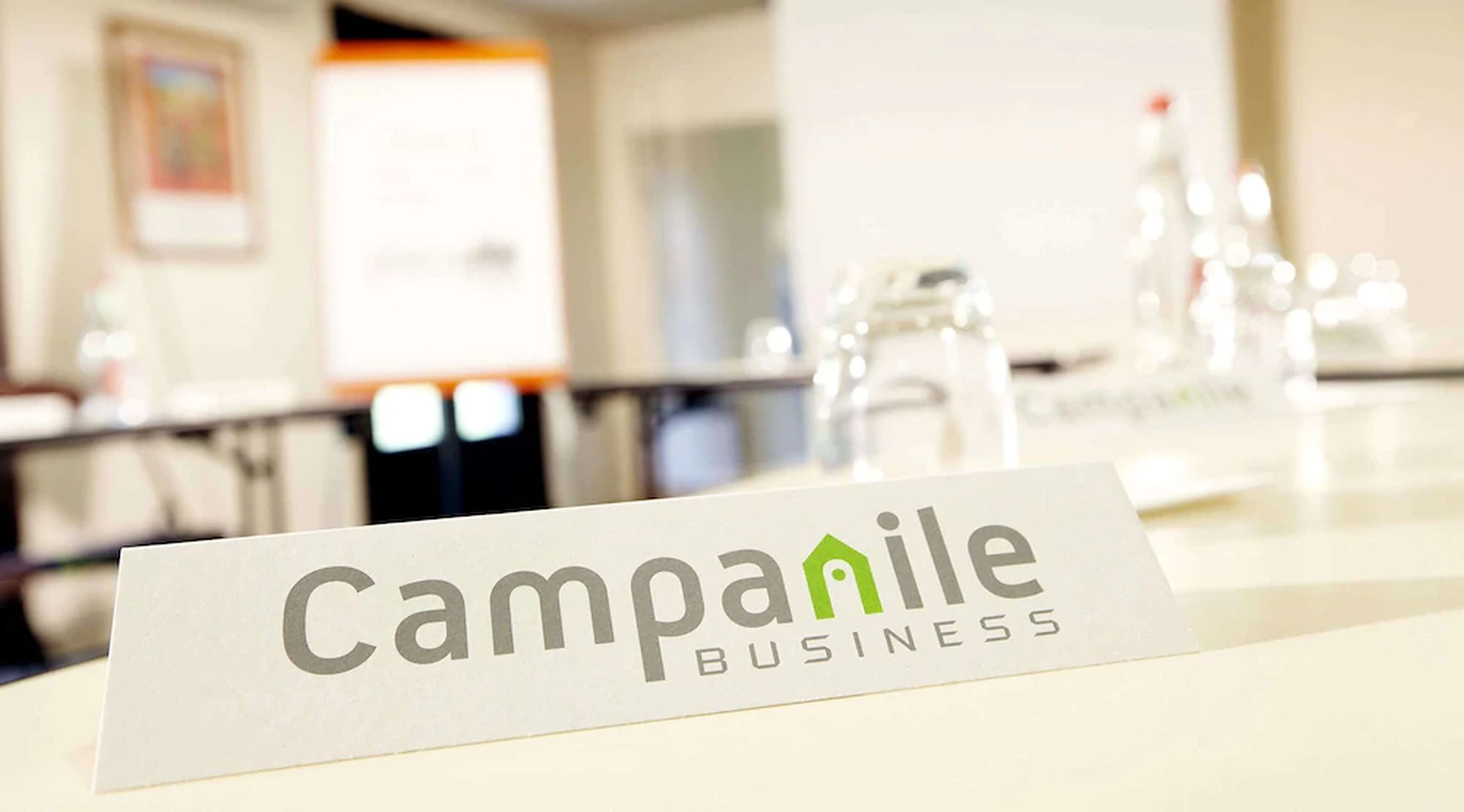 A sign for Campanile Business with a modern interior background.