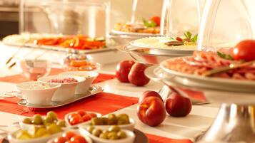 Un bufé con diversas opciones de comida y frutas.