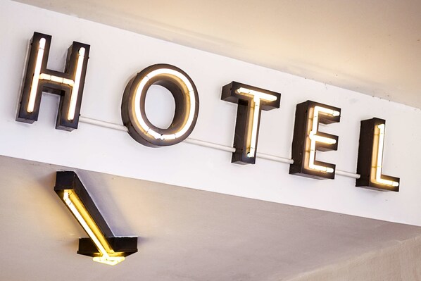 Illuminated letters spelling "HOTEL" on a wall.
