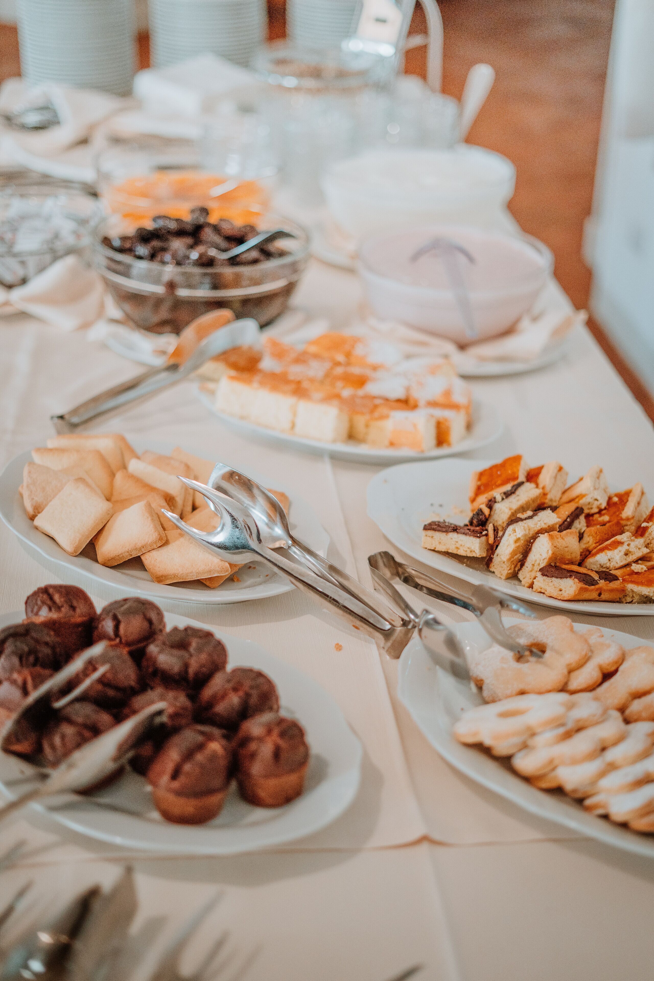 A buffet table with various food items and utensils.