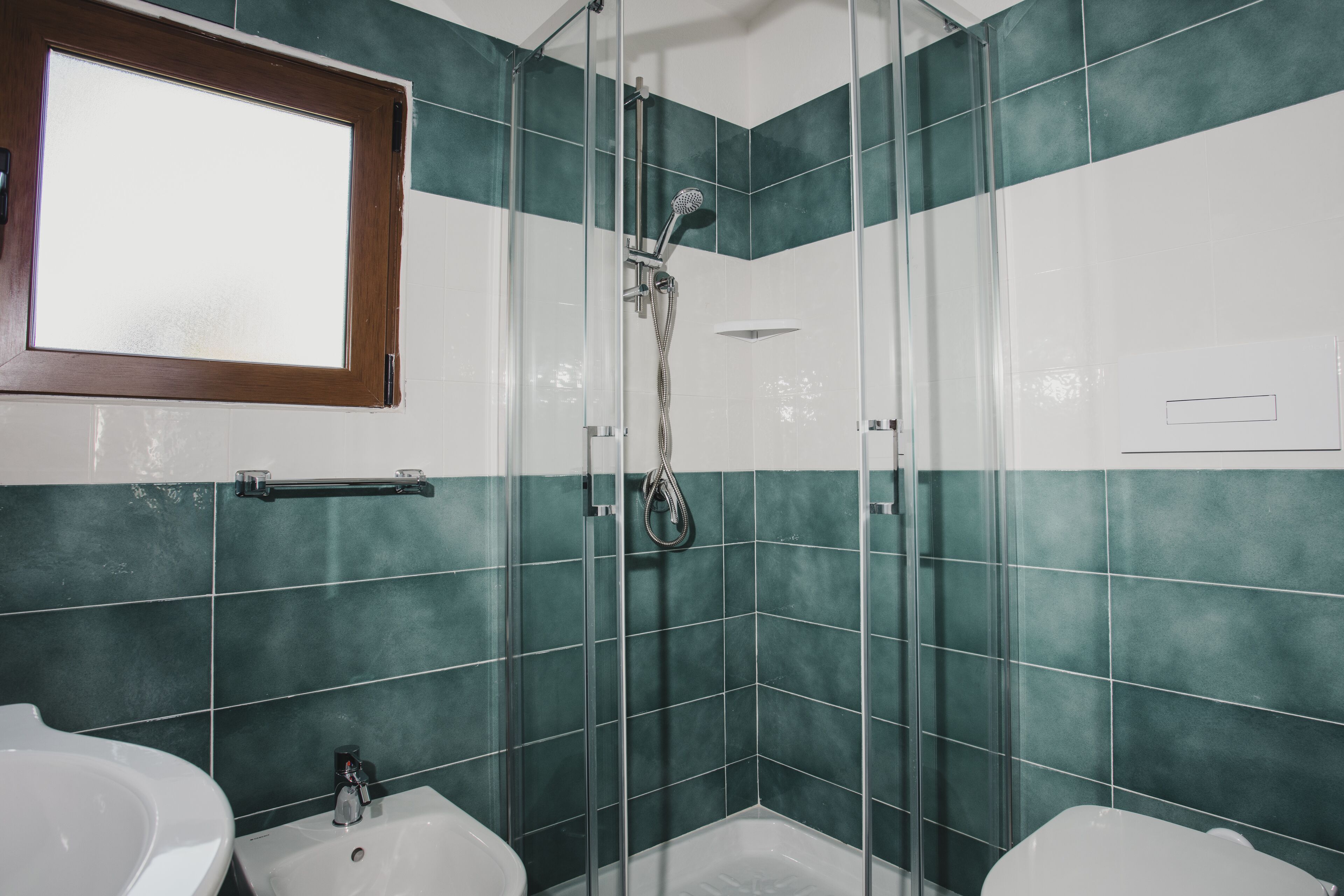 A bathroom with a shower, two sinks, and a mirror.