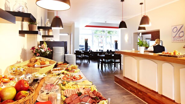 A buffet setup with various food items and a bar area. - Hotel Ostseehalle Kiel by Premiere Classe (Kiel)