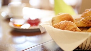 A basket of croissants on a table with a blurred background. - Hotel Ostseehalle Kiel by Premiere Classe (Kiel)