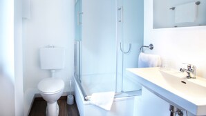 A modern bathroom with a glass shower enclosure, a white toilet, and a sink with a mirror above it. - Hotel Ostseehalle Kiel by Premiere Classe (Kiel)